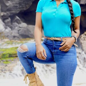 Woman standing confidently outdoors in a polo shirt and denim jeans, showcasing a casual and trendy style.